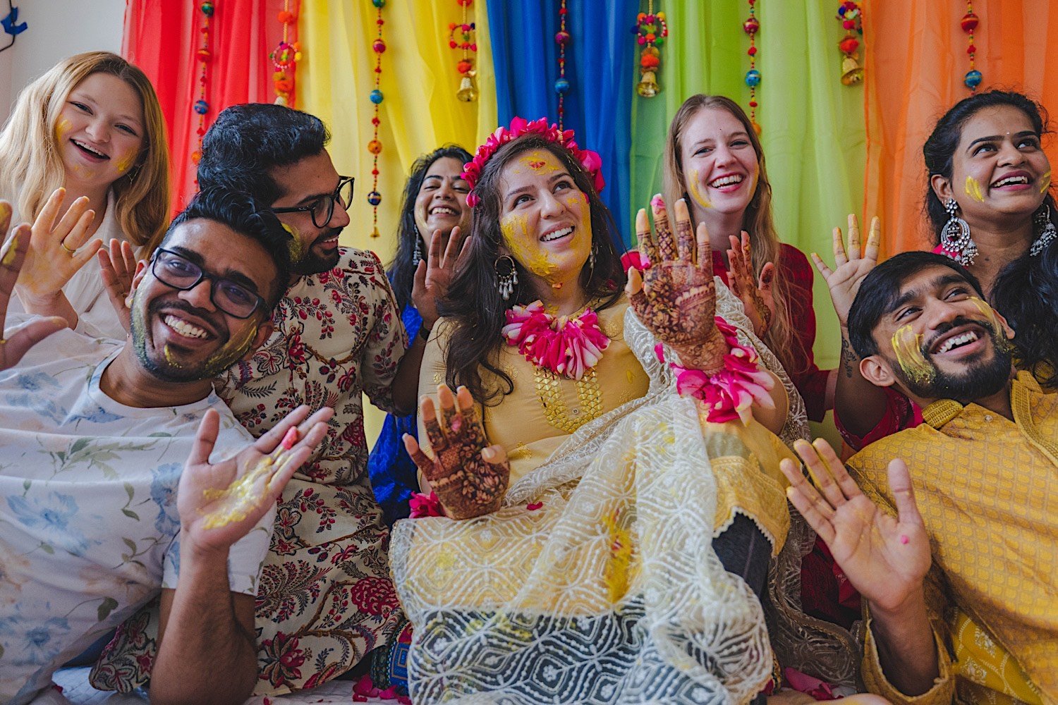 Bride to be and wedding party all smile at the camera after traditional Haldi celebration