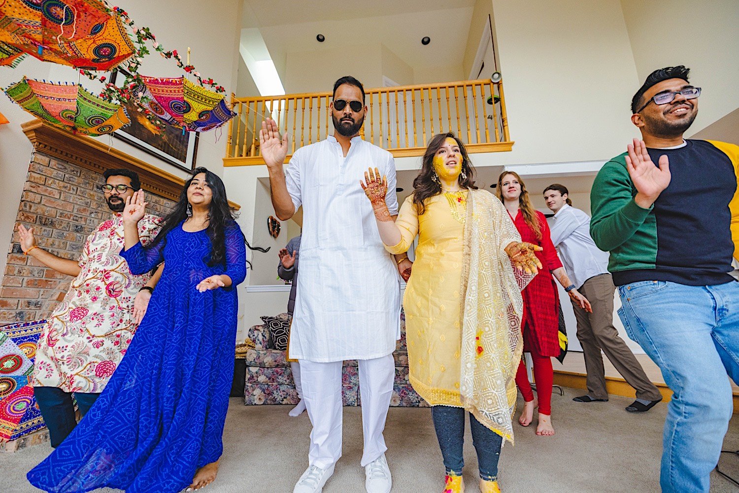 Bride, groom and wedding party all dance together at traditional Haldi celebration