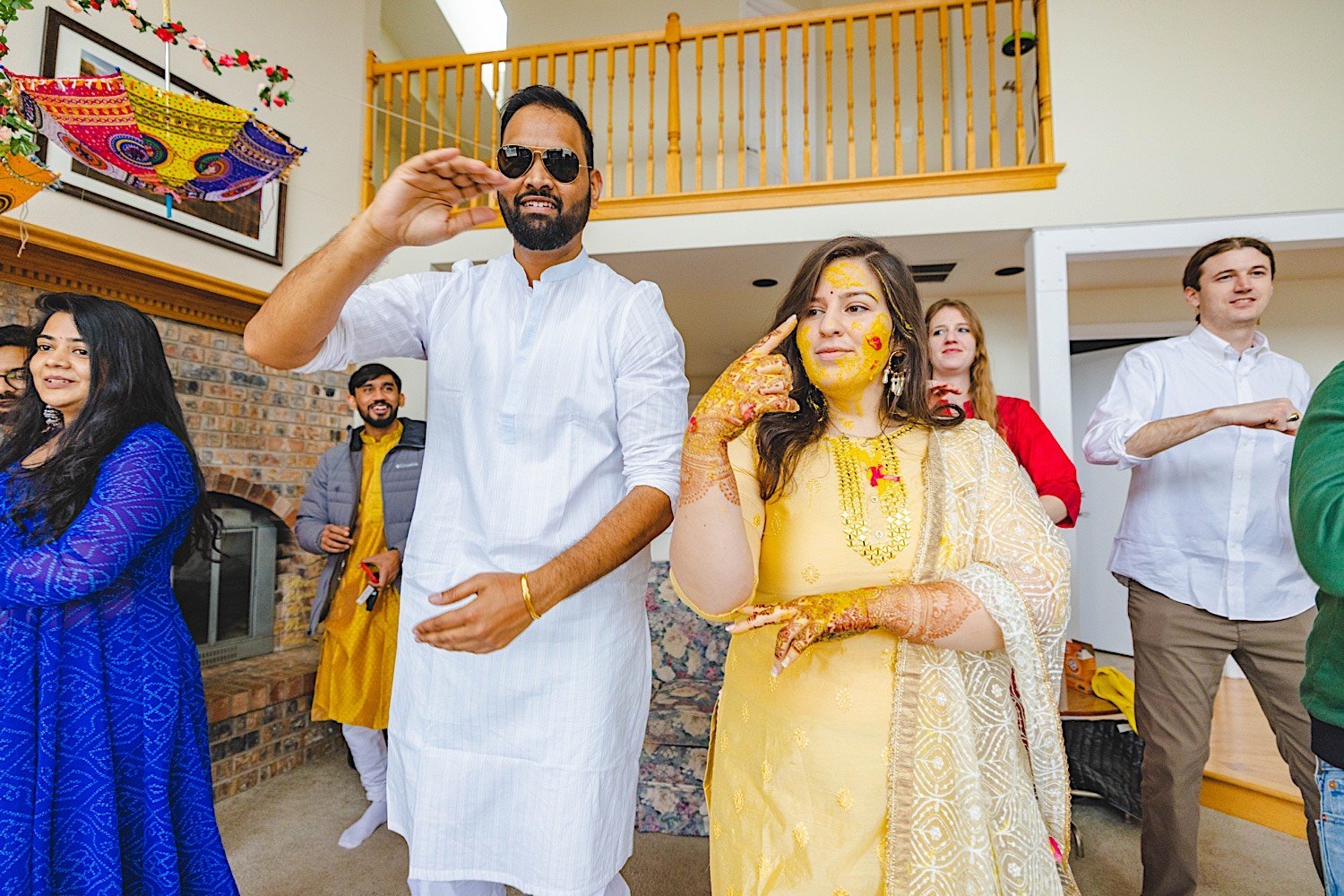 Bride, groom and wedding party all dance together at traditional Haldi celebration