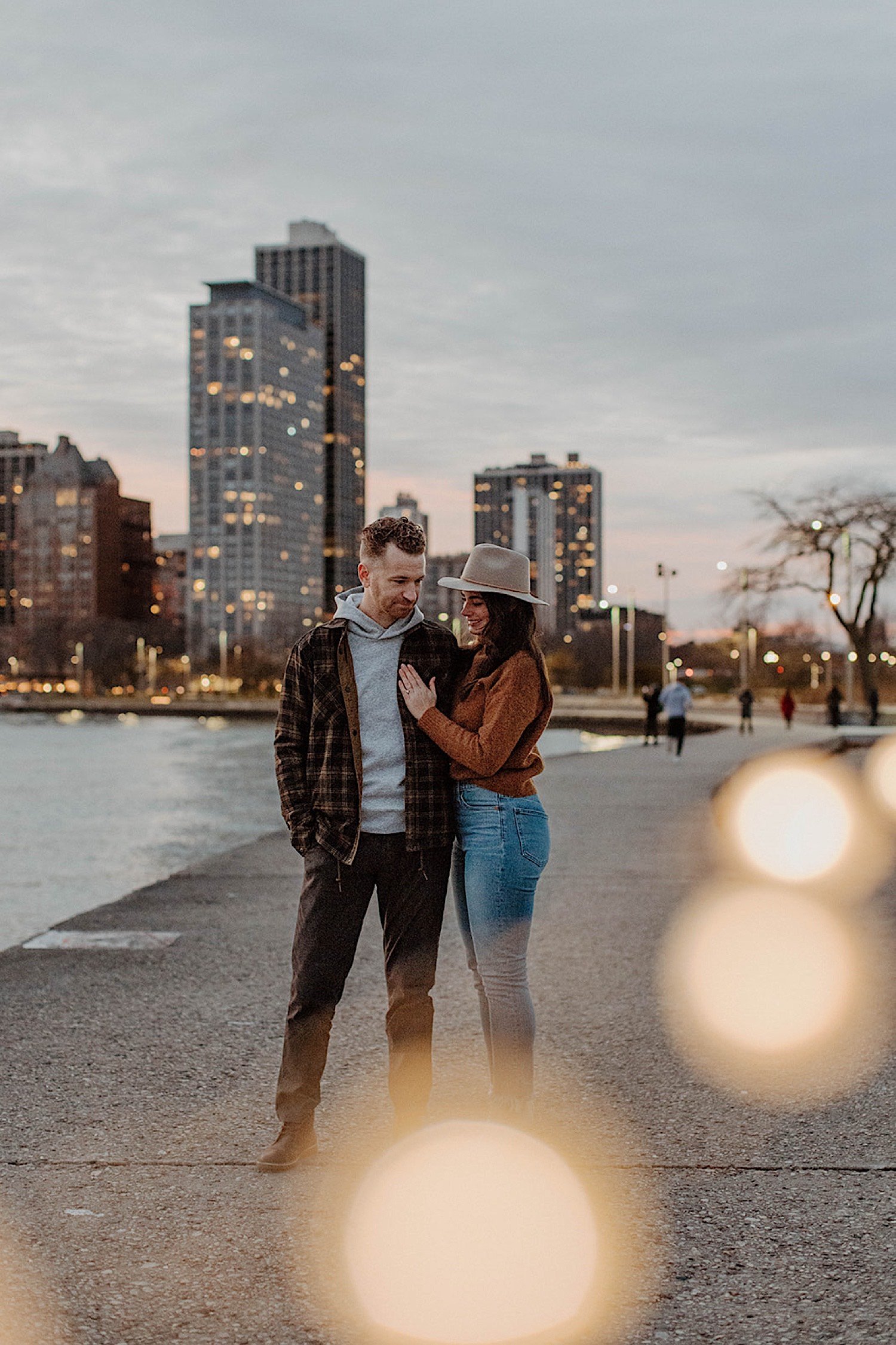 Woman shows off her engagement ring standing next to fiancé at Chicago's North Avenue Beach