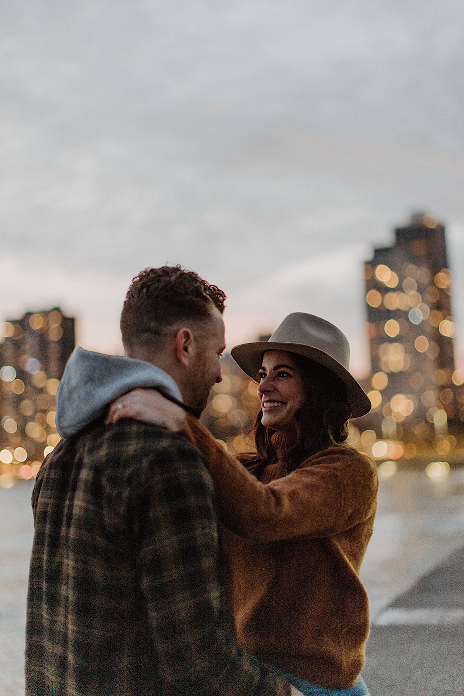 Couple smile at each other with Chicago's skyline in the background