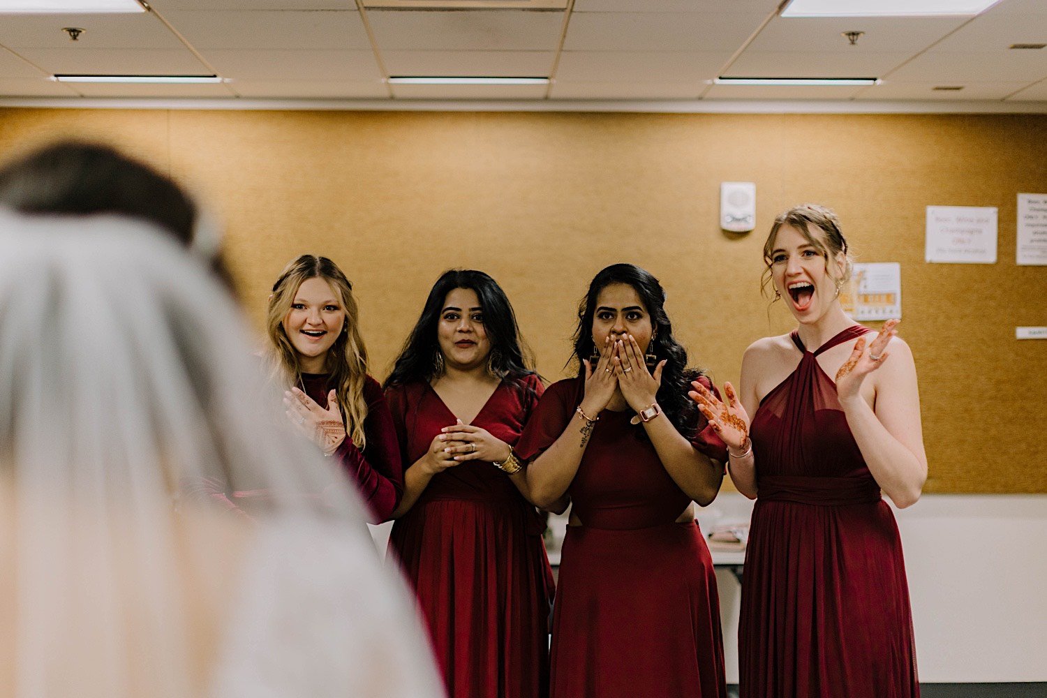 Bridal party reacting to seeing the bride's dress for the first time