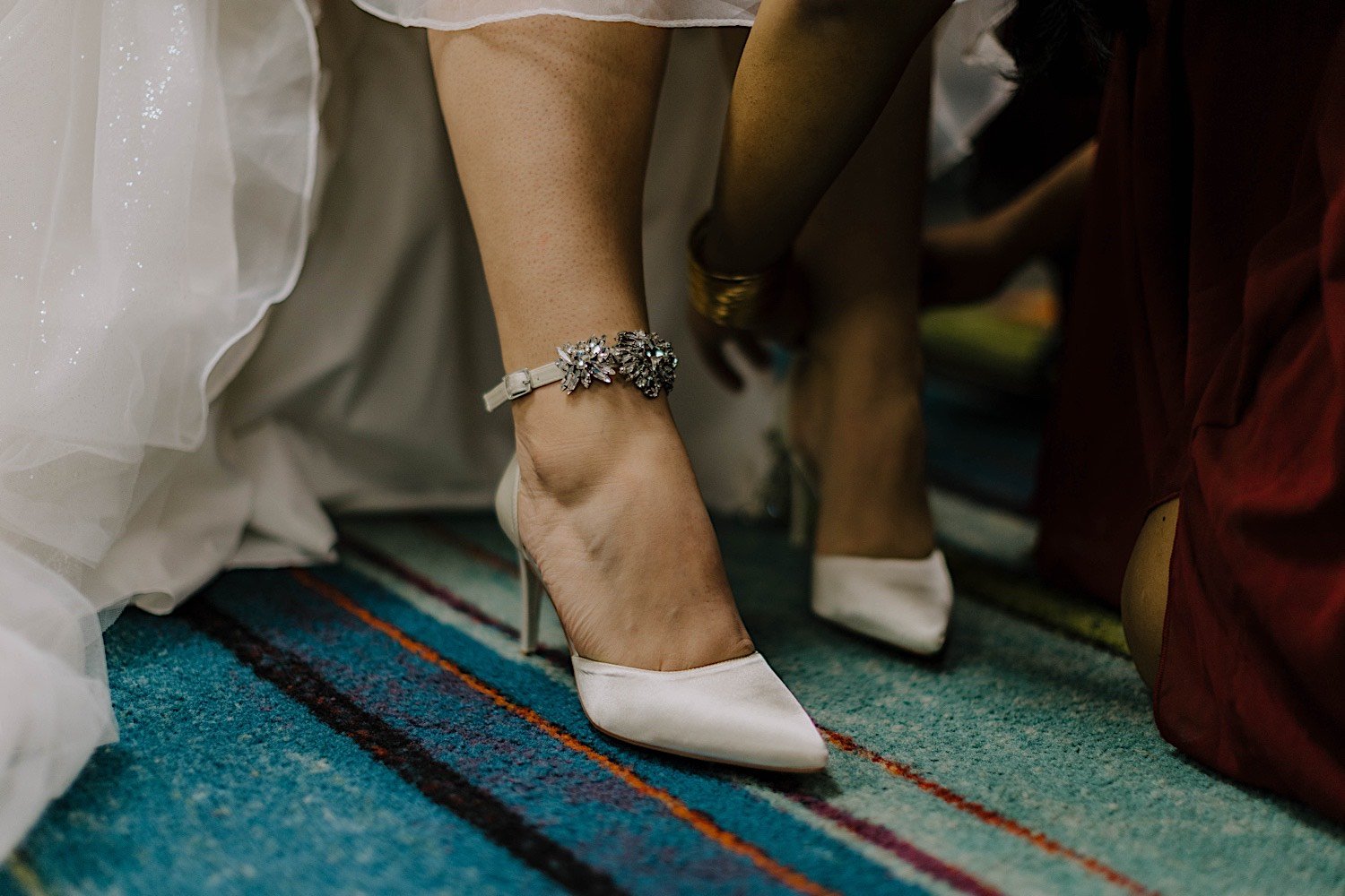 Close up of bride's shoes and anklet while wearing her wedding dress