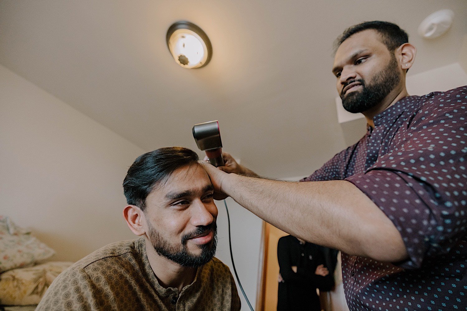 Man giving his friends hair a quick trim as they prepare for a wedding