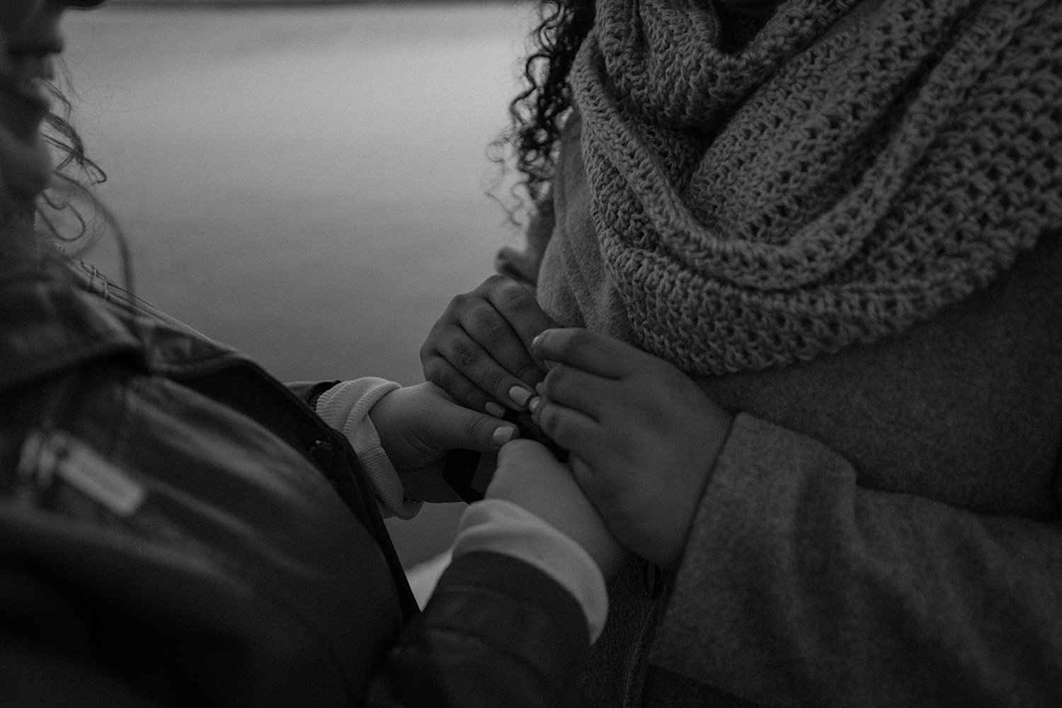 Black and white photo of a close up of a couple holding hands