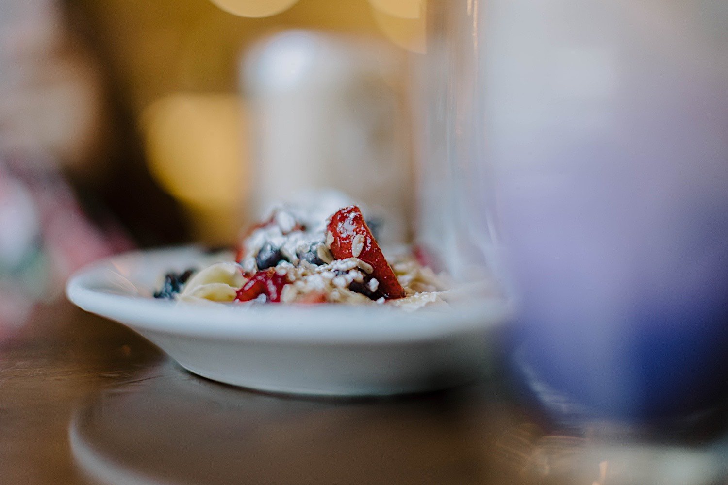 Strawberries, blueberries and oatmeal on a plate with blurry surroundings