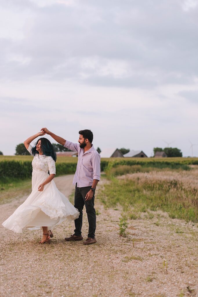 A couple dance in a Chicagoland cornfield during their newlywed session