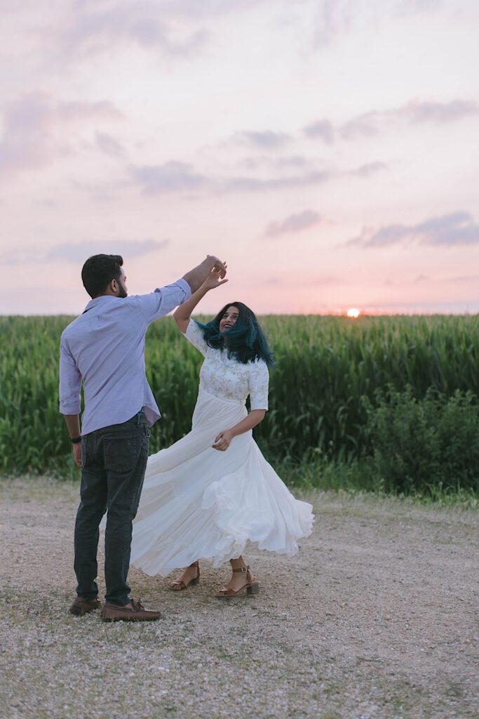 A couple dance in a Chicagoland cornfield during their newlywed session at sunset