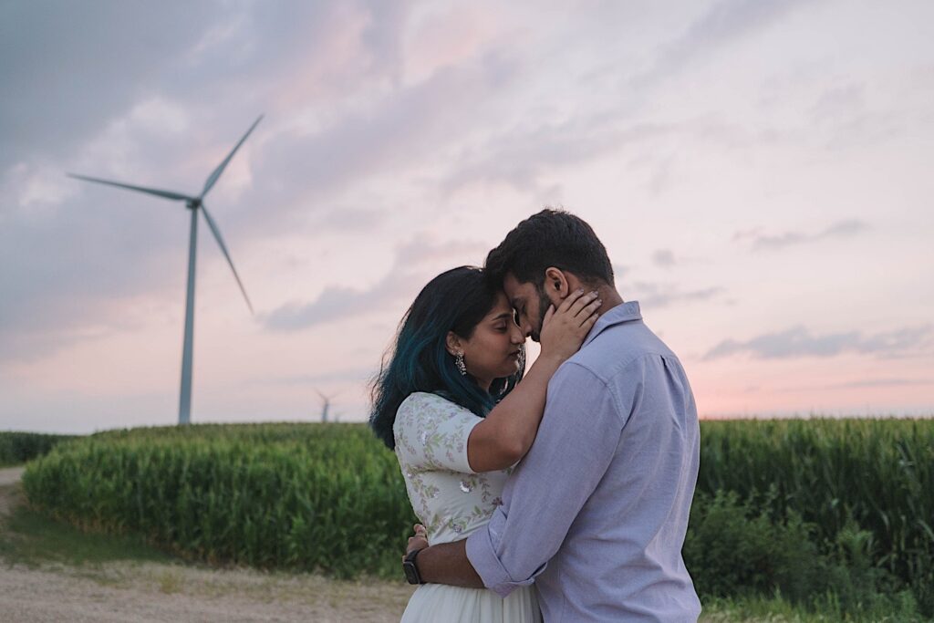 A couple embrace and touch their foreheads together during their newlywed session in a Chicagoland cornfield.