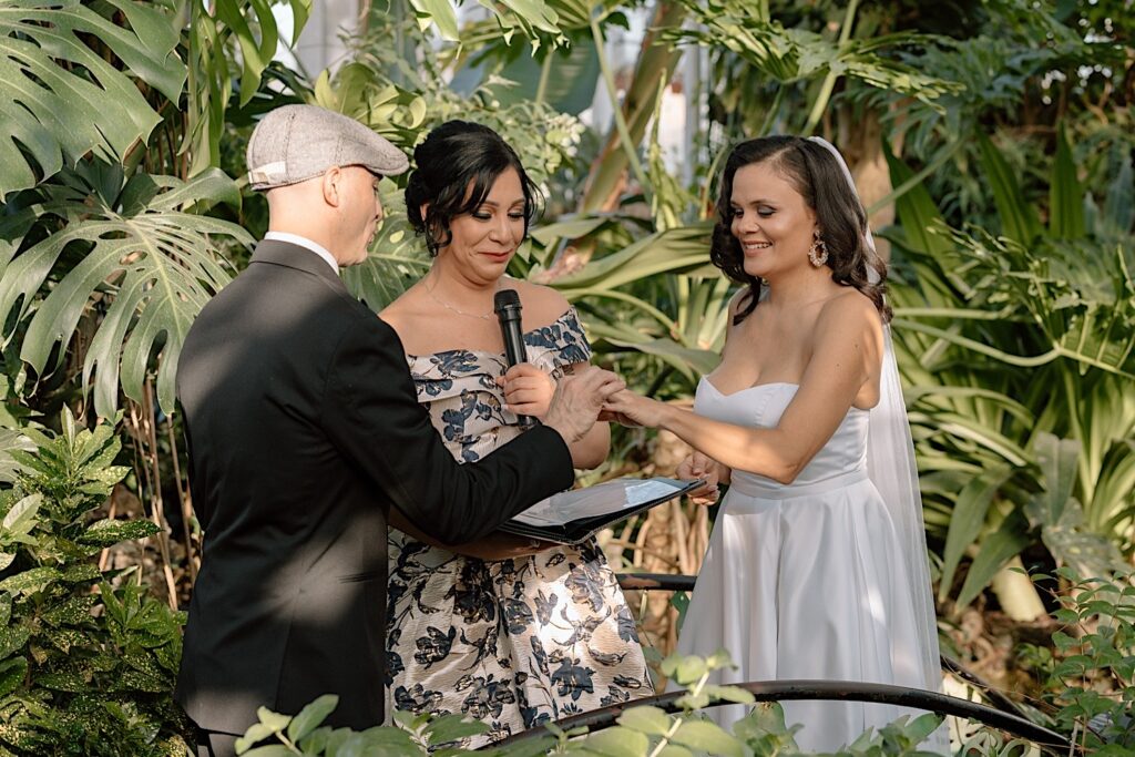 A couple exchanges wedding rings during their elopement in one of Chicago's arboretums